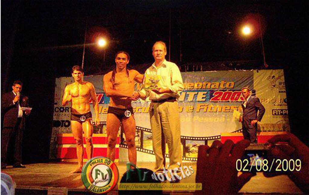 Momento histórico do esporte paraibano em 2009! O jornalista Petrúcio Prado sobe ao palco do XI Campeonato Paraibano de Fitness e Musculacao para realizar a entrega oficial do troféu ao atleta Edriano Souza.