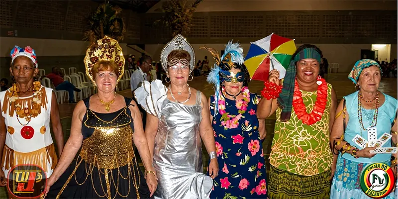 Baile Carnaval dos Idosos com seis mulheres idosas sorridentes e fantasiadas na quadra