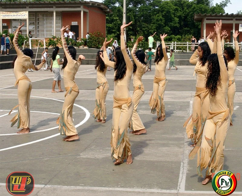 Grupo de dança composto por jovens bailarinas realizando uma coreografia ao ar livre durante a ação voluntária na Fundação Bradesco.